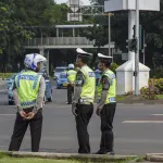 Petugas kepolisian mengatur lalu lintas di jalan raya