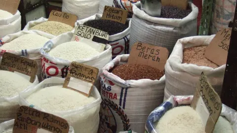Pedagang beras di pasar tradisional melayani pembeli